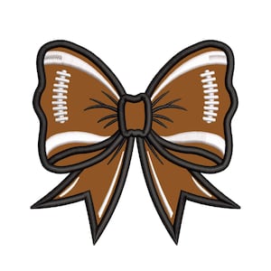May include: A brown and white football-themed bow with a black outline. The bow is made of fabric and has a stitched design.