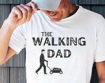 Könnte beinhalten: Weißes T-Shirt mit schwarzem Text "The Walking Dad" und einer Grafik einer Person, die einen Rasenmäher schiebt.