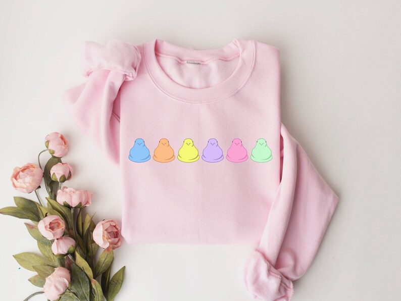 Peut inclure: Un sweat-shirt rose avec une rang&eacute;e de six guimauves color&eacute;es imprim&eacute;es sur le devant.