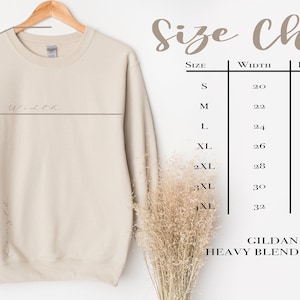 May include: Size chart for a Gildan 18000 heavy blend crewneck sweatshirt. The chart shows measurements in inches for width, length, and sleeve length for sizes S through 4XL.