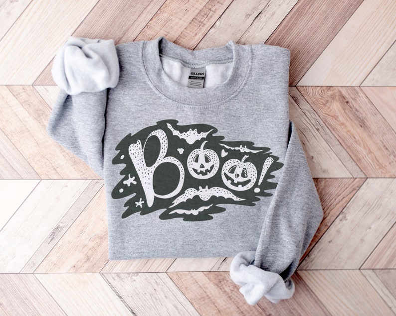 May include: Gray sweatshirt with a white graphic of the word "BOO!" with bats and jack-o'-lanterns.