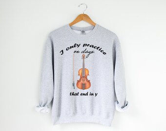 May include: A gray sweatshirt with the text "I only practice on days that end in y" and a drawing of a violin and bow.