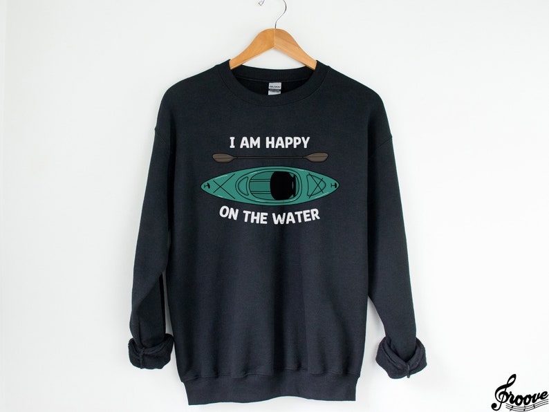 May include: Black sweatshirt with a white graphic print of a kayak and paddles. The text reads "I am happy on the water."