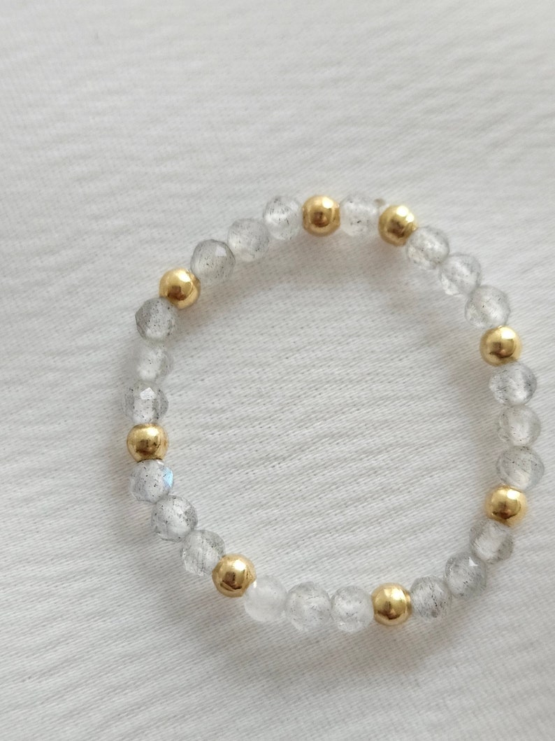 May include: A bracelet made of clear faceted beads with gold accents. The bracelet is made of natural stones and is a beautiful and unique piece of jewelry.