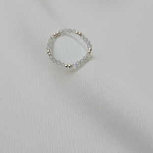 May include: A silver ring with small, clear, faceted beads and silver beads.