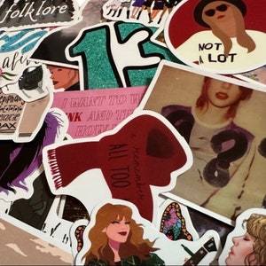 May include: A collection of colorful stickers featuring illustrations and text. Designs include portraits, song lyrics, and the word "folklore". The stickers vary in size and shape, with a mix of bold and pastel colors.