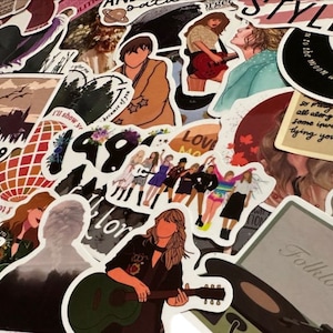 May include: A collection of colorful stickers featuring various designs. The stickers include illustrations of a singer playing a guitar, text that says "Style", and other graphics. The stickers are of various shapes and sizes.