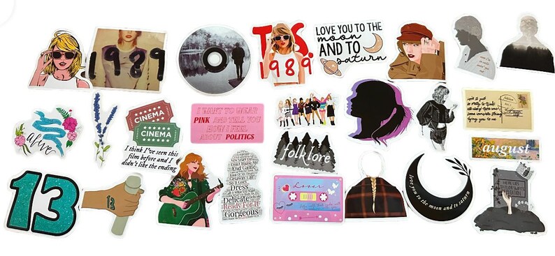May include: A collection of colorful stickers featuring various designs. Includes stickers with the text "1989", "folklore", "august", and "LOVE YOU TO THE MOON AND TO SATURN". Other stickers feature illustrations of a woman, a cassette tape, and a number 13.