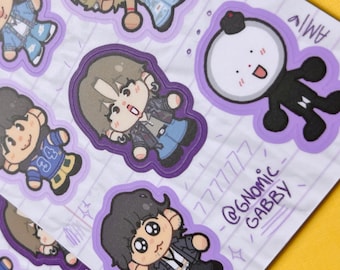 May include: A sticker sheet featuring multiple chibi-style character illustrations with purple outlines. The designs include figures in casual outfits, a round white character with a black body, and handwritten text reading 7777777 @GNOMIC GABBY.
