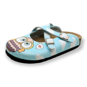 May include: Light blue children's slip-on shoe with a cartoon owl design and two adjustable straps with white buckles. The shoe has a white cloud pattern and a black sole.