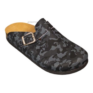 May include: Black and gray camouflage print clog with a brown cork sole and a silver buckle.