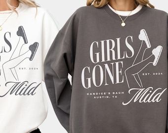 May include: Two sweatshirts in white and charcoal gray with a graphic design of a pair of legs in sneakers with the text "Girls Gone Mild" and "Candice's Bach Austin, TX" and "Est. 2024".