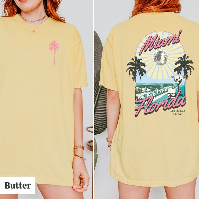 May include: A yellow t-shirt with a pink palm tree on the front and a graphic on the back that says "Miami Florida" with a palm tree, a disco ball, and a martini glass. The graphic also says "Kirsten's Bach Est. 2014".