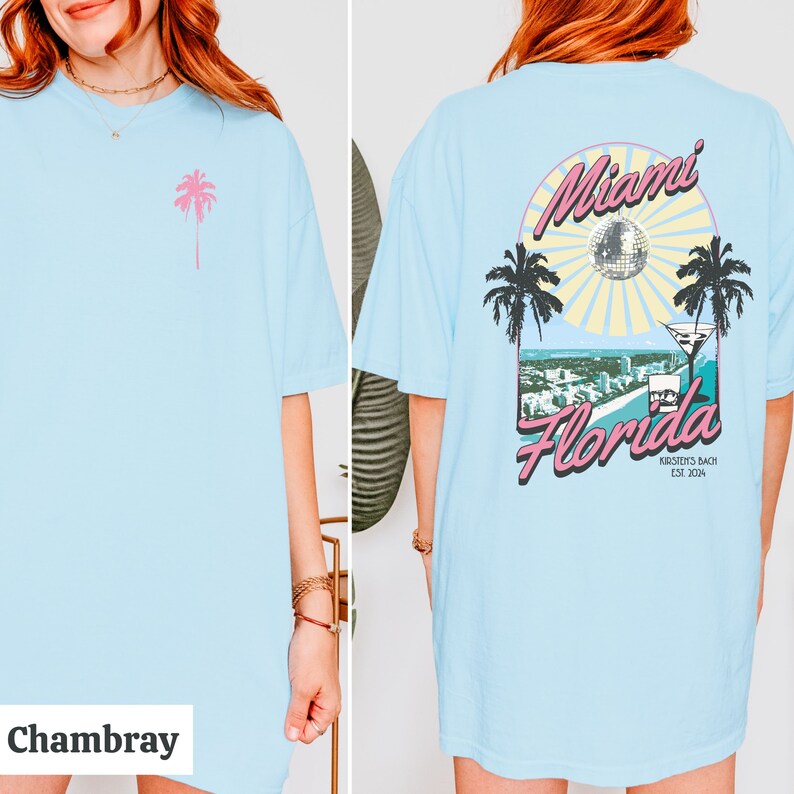 May include: A light blue t-shirt with a pink palm tree on the front and a graphic on the back that says "Miami Florida" with a disco ball, palm trees, and a martini glass. The graphic also says "Kirstein's Beach Est. 2014".