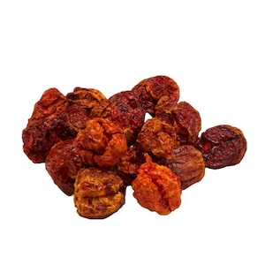 Puede incluir: Un montón de chiles rojos-anaranjados secos y arrugados. Los chiles tienen una textura rugosa y diferentes tonos de rojo y marrón. La imagen está sobre un fondo blanco liso, destacando el color y la textura de los chiles.