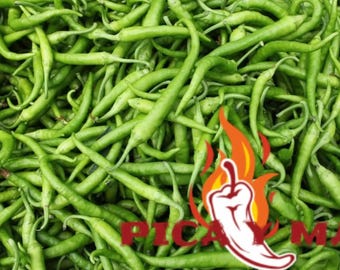 May include: A close-up of a mass of fresh, vibrant green chili peppers. The peppers are long and thin, with a gentle curve. A logo featuring a chili pepper and flames is in the bottom right corner.
