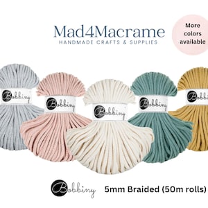 May include: Five spools of 5mm braided macrame cord in various colors: gray, pink, cream, teal, and mustard yellow. Each spool is labeled "Bobbiny" and is 50 meters long. The image also includes the text "Mad4Macrame HANDMADE CRAFTS & SUPPLIES".