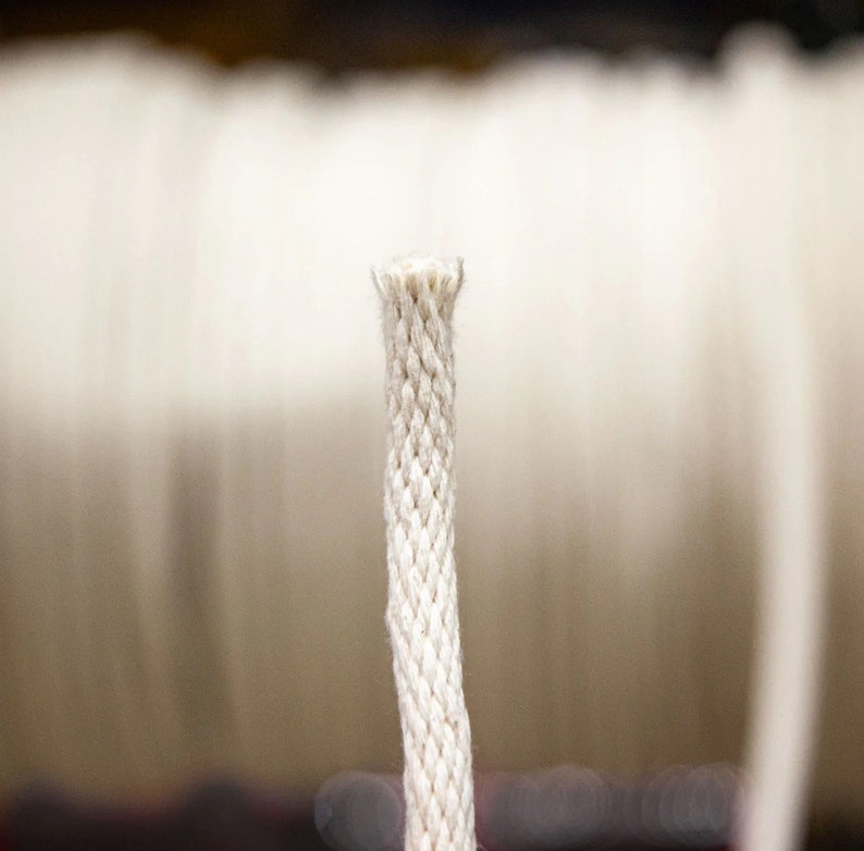 May include: Close-up of a white cotton cord, showing the braided texture.