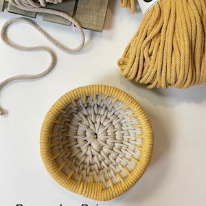 May include: A handmade beige and honey-colored woven basket. The basket is round with a textured surface. The image also shows spools of beige and honey-colored yarn, and the text "Base color- Beige Top color- Honey".