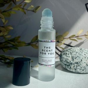 May include: A clear glass roller bottle with a black cap and a white label that reads "THE SCENT FOR YOU TAILOR-MADE PERFUME/OIL 10ML".