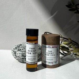 May include: Two brown glass bottles with black caps and white labels. The labels say "The Scent For You" and "Tailor-Made Perfume/Oil 10ML".