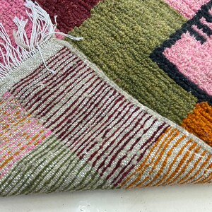 a close-up view of a colorful, multicolored rug with a geometric pattern.