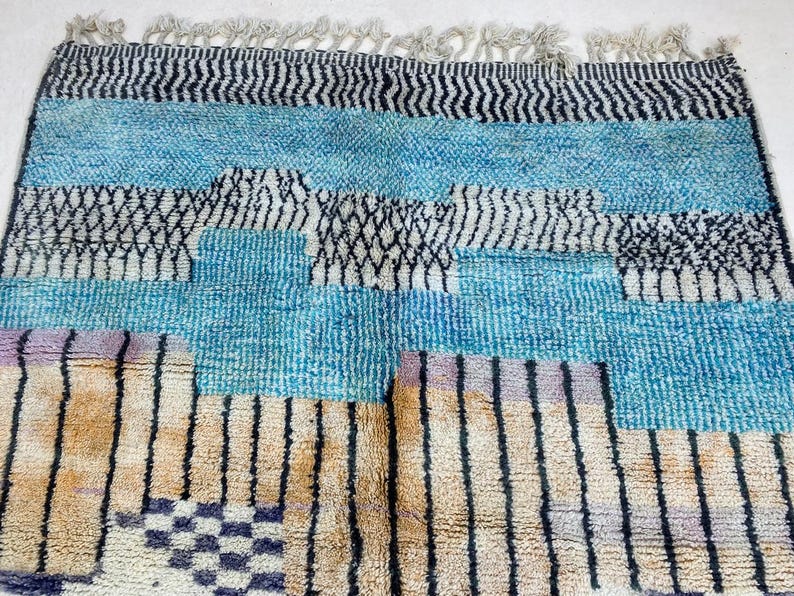 a colorful, patterned rug with a mix of blue, black, and white stripes and geometric shapes.