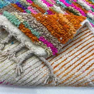 a close-up view of a colorful, multicolored rug or carpet with a variety of patterns and textures.