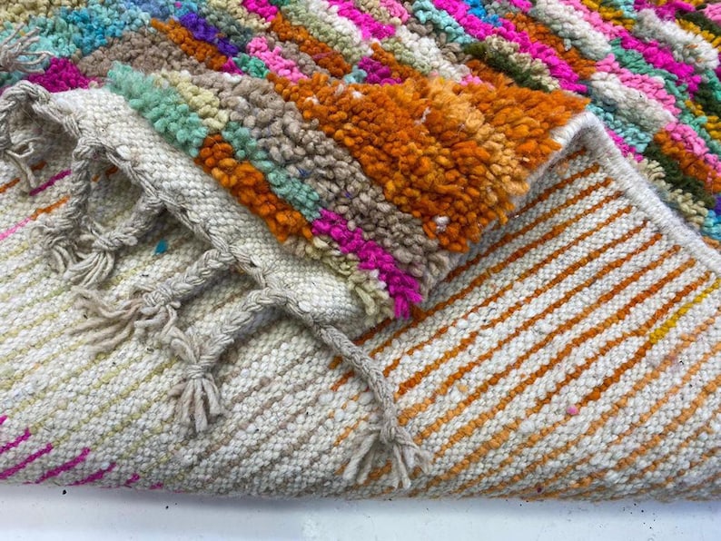 a close-up view of a colorful, multicolored rug or carpet with a variety of patterns and textures.