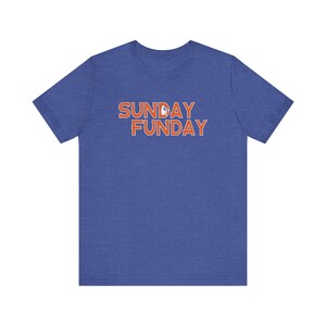 Pu&ograve; includere: T-shirt blu a maniche corte con le parole "SUNDAY FUNDAY" in lettere arancioni. Il testo ha un contorno bianco. La maglietta &egrave; realizzata in un materiale morbido.