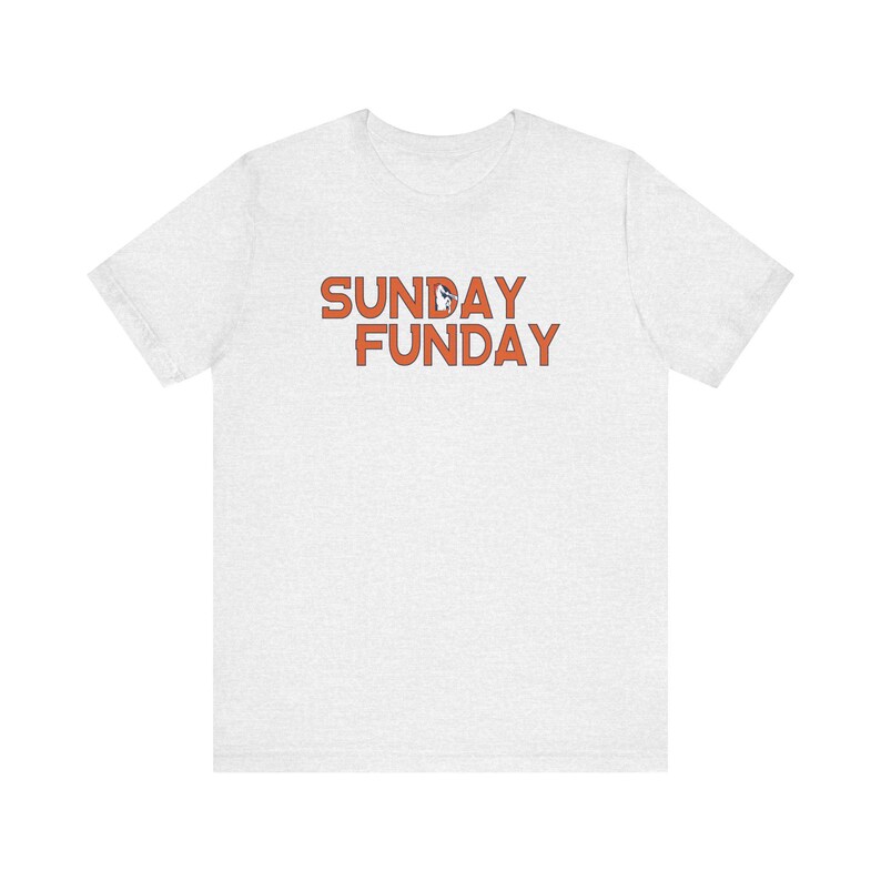 Pu&ograve; includere: T-shirt grigio chiaro con la scritta arancione "SUNDAY FUNDAY". Il testo &egrave; in un carattere giocoso e la maglietta sembra essere fatta di un materiale morbido e confortevole.
