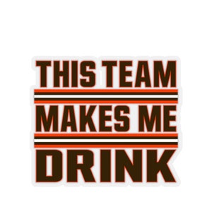 May include: A white sticker with brown and orange stripes and the text "THIS TEAM MAKES ME DRINK" in brown.