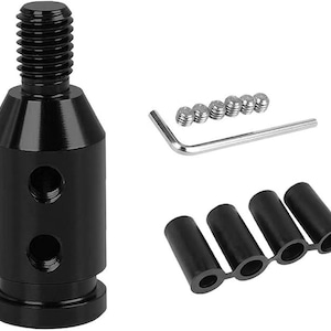 Puede incluir: Un kit adaptador de pomo de cambio de coche de metal negro. El kit incluye un adaptador roscado, tornillos de fijaci&oacute;n, una llave Allen y cuatro manguitos de goma negros. El adaptador tiene dos agujeros y una parte superior roscada.