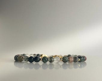 May include: A bracelet made of green, white and pink agate beads with gold accents.