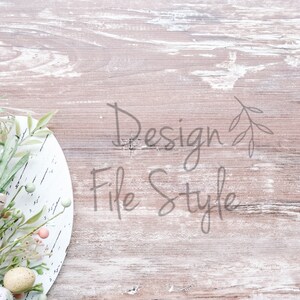 May include: A white plate with a green and brown floral arrangement with pastel colored eggs on a light brown wood background. The text "Design File Style" is written in gray on the wood.