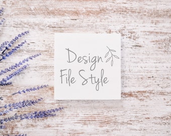 May include: A white card with the text "Design File Style" written in gray cursive script with a small gray twig design above the text. The card is on a whitewashed wood background with purple lavender flowers to the left.
