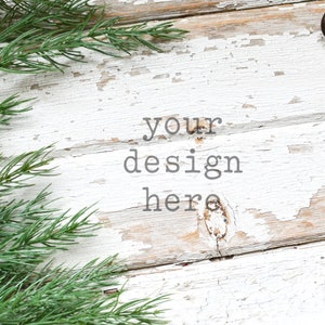 May include: A rustic white wooden background with a pine branch and small brown bells. The text "your design here" is written in the center of the image.