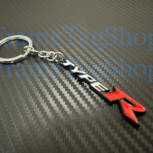 May include: Silver key chain with a black and red metal charm that says "TYPE R".