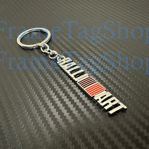 May include: Silver key chain with a red and white logo that says "HOLMART" on it.