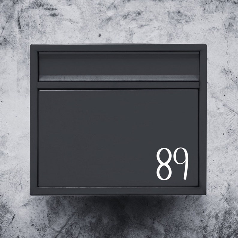 Puede incluir: Un buz&oacute;n de metal negro con el n&uacute;mero 89 impreso en blanco en la parte delantera.