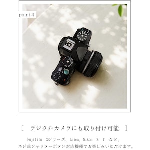 May include: A black and silver digital camera with a lens, on a white surface. The camera features various dials and buttons. The image includes the text "point 4" and Japanese text about compatibility with Fujifilm, Leica, and Nikon cameras.