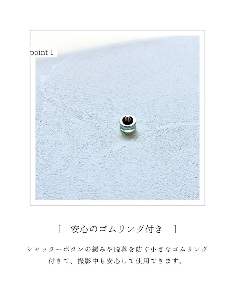 May include: A small, silver button with a green centre, set against a light blue textured background. The text "point 1" is in the upper left corner. The button is likely a camera accessory.