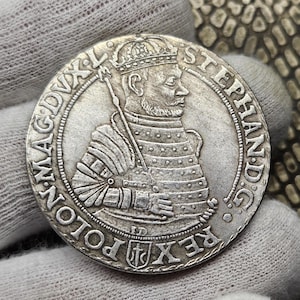 Puede incluir: Moneda de plata con el retrato del rey Esteban I de Polonia, con una corona y armadura. La inscripción alrededor del retrato dice "STEPHANUS D.G. REX POLON. MAG.DVX.L."