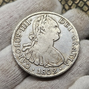 Könnte beinhalten: Silbermünze mit einem Porträt einer Person mit einer Krone und dem Text "CAROLUS III. DEI. GRATIA. 1802" am Rand.