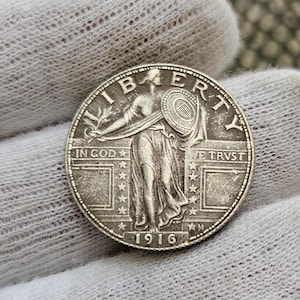 Puede incluir: Una moneda de plata de medio dólar de 1916 Walking Liberty con las palabras "LIBERTY", "IN GOD WE TRUST" y "1916" visibles. La moneda presenta a una mujer caminando con una antorcha y un escudo.