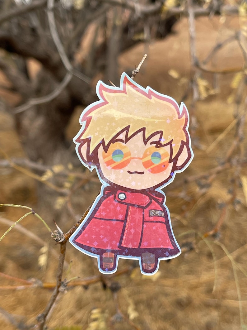 May include: A cartoon sticker of a person with blond hair wearing red clothing and sunglasses. The sticker has a sparkly, iridescent finish.