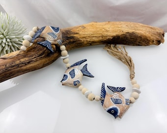 3 peixes numa corda, carrilhão de vento, madeira flutuante, contas de madeira, seixos, cabide, corrente de madeira para pendurar decoração marítima de jardim azul/bege, com cerca de 1 m de comprimento.
