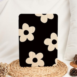 Könnte beinhalten: Schwarze iPad-Hülle mit einem Muster aus beigefarbenen, stilisierten Blumen.