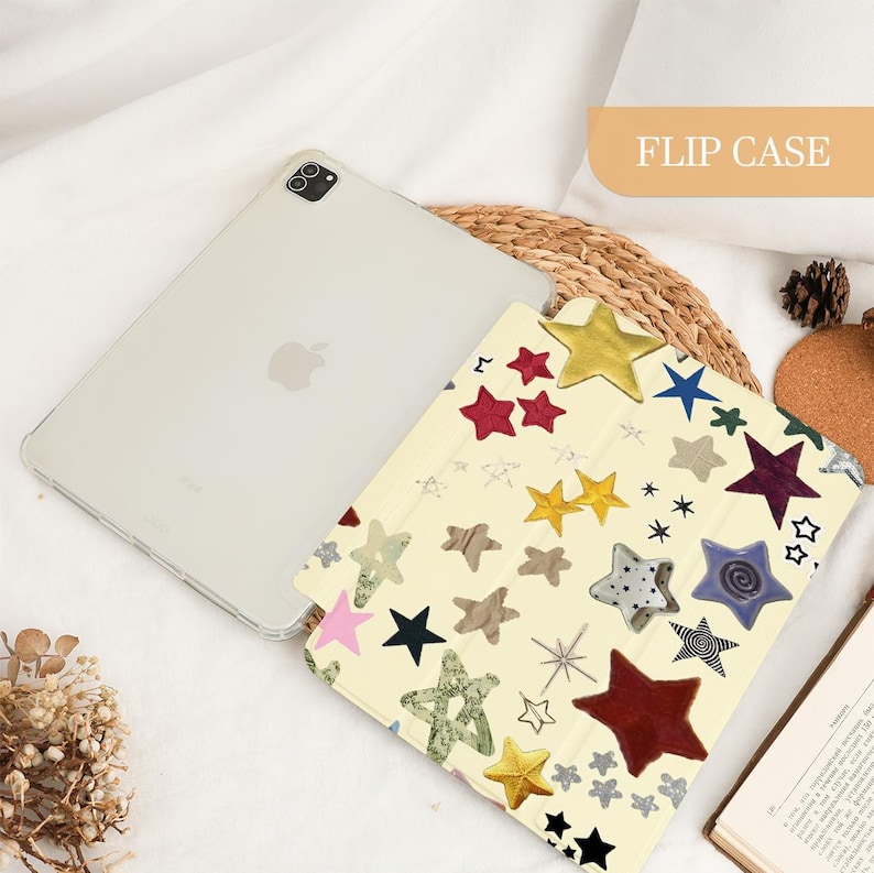 May include: A light-colored tablet with a clear case and a flip case featuring a star pattern in various colors. The flip case has the words "FLIP CASE" in a rectangular box. The stars are in red, yellow, blue, and black.