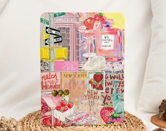 May include: A rectangular art print featuring a collage of New York City imagery. The print includes a pink telephone booth, street signs, strawberries, a perfume bottle, and text that reads "The New Yorker" and "Match Made in Heaven."